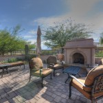 Large back patio with outdoor fireplace, mountain views, and access to walking trails