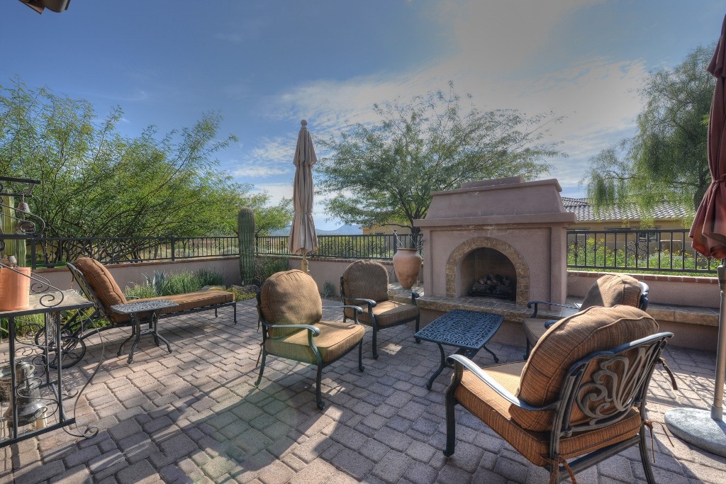 Large back patio with outdoor fireplace, mountain views, and access to walking trails
